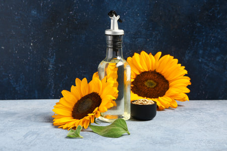 Sunflowers, seeds and bottle of oil on blue backgroundの写真素材