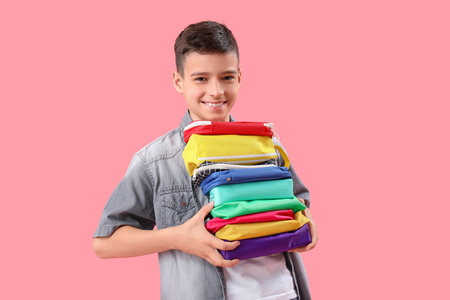Little boy with pencil case on pink backgroundの写真素材