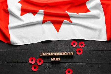 Poppy flowers with flag of Canada on black wooden background. Remembrance Dayの写真素材