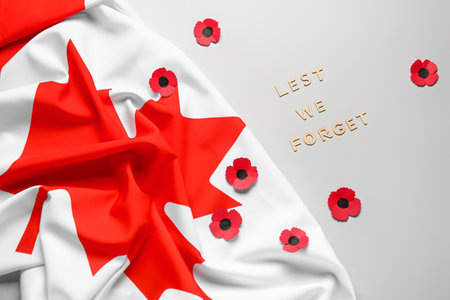Poppy flowers with flag of Canada and text LEST WE FORGET on gray background. Remembrance Dayの写真素材