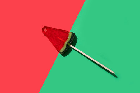 Lollipop in shape of watermelon slice on colorful backgroundの写真素材