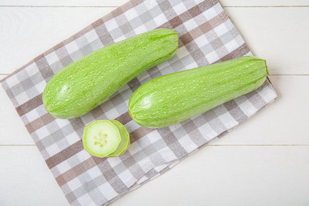 Fresh green zucchini on white wooden backgroundの写真素材