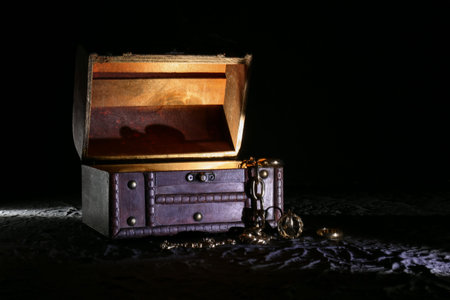 Decorative box with jewelery and glowing light on black background