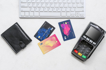 Keyboard with leather wallet, payment terminal and credit cards on white background