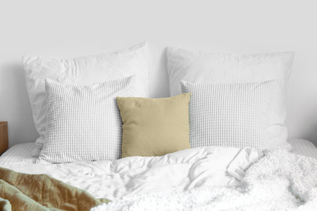 Soft pillows and white blanket on bed, closeup