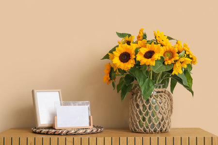 Vase with beautiful sunflowers on wooden cabinet near beige wallの写真素材