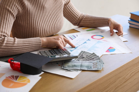 Female student sitting at table and calculating her finances. student loan conceptの写真素材