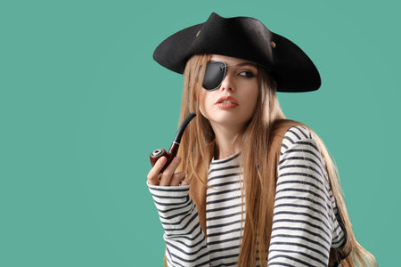 Beautiful female pirate smoking pipe on green backgroundの写真素材