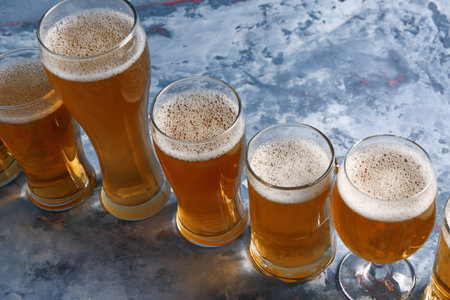 Glasses and mug of cold beer on blue background. celebration