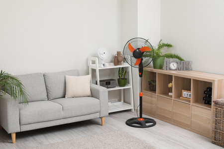 Interior of light living room with gray sofa and modern floor fanの写真素材