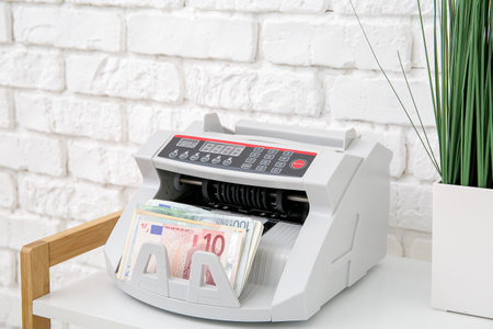 Cash counting machine with euro banknotes on shelf in office, closeupの写真素材