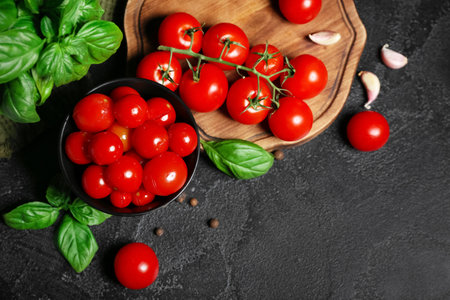 Bowl with canned tomatoes and basil on black backgroundの写真素材