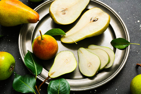 Plate with ripe pears on black table, closeupの写真素材