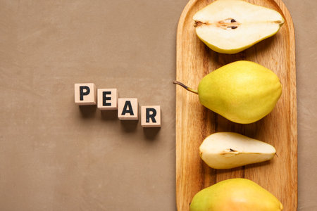 Word PEAR and wooden board with fresh fruits on brown backgroundの写真素材
