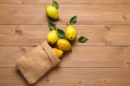 Sack bag with fresh pear and leaves on wooden backgroundの写真素材