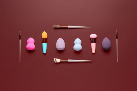 Makeup sponges and brushes on red backgroundの写真素材