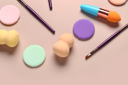 Makeup sponges and brushes on beige backgroundの写真素材