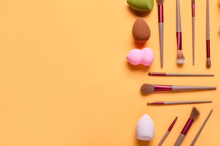Makeup sponges and brushes on orange backgroundの写真素材