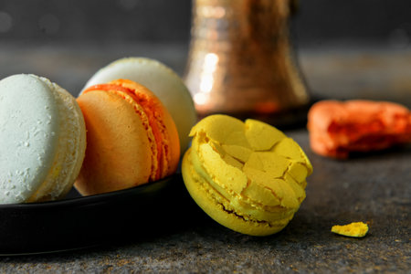 Plate with sweet macaroons on dark tableの写真素材