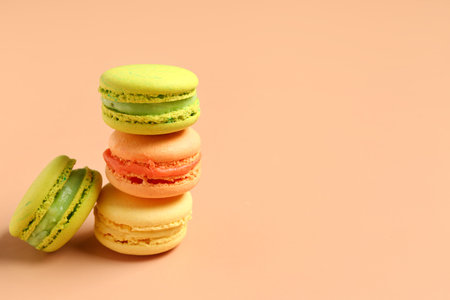 Different tasty sweet macaroons on orange backgroundの写真素材