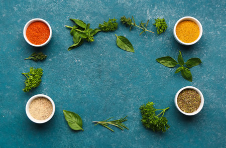 Frame made of fresh herbs and spices on color backgroundの写真素材
