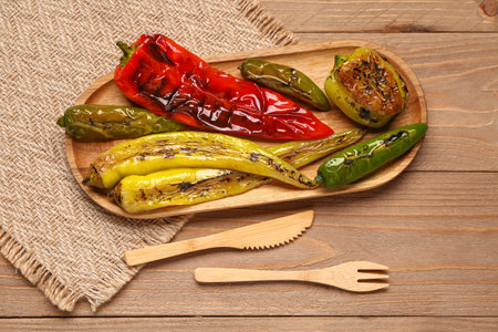 Board with different grilled peppers on wooden backgroundの写真素材
