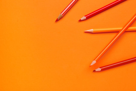 Different pencils on orange backgroundの写真素材