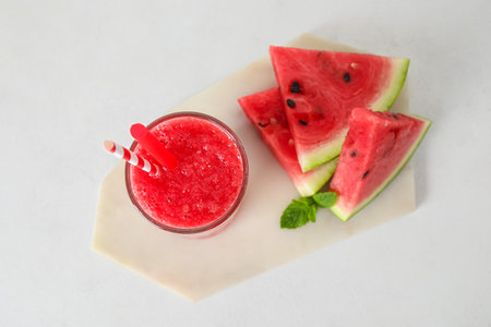 Glass of tasty watermelon juice and mint on white backgroundの写真素材