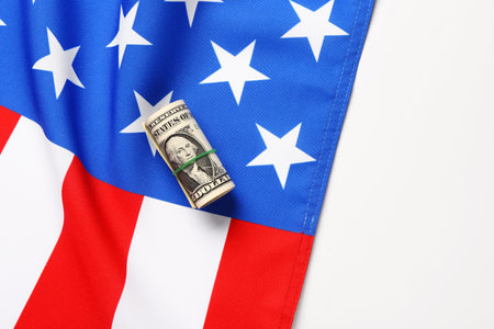 USA flag and roll of dollar banknotes on white backgroundの写真素材