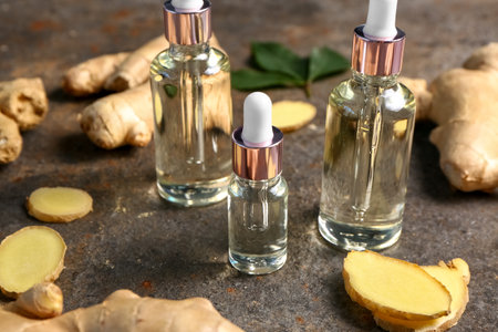 Bottles of ginger cosmetic oil on dark backgroundの写真素材