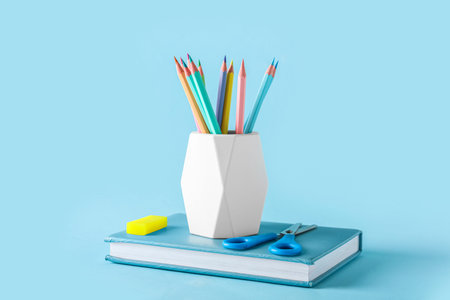 Set of stationery with different pencils on color background