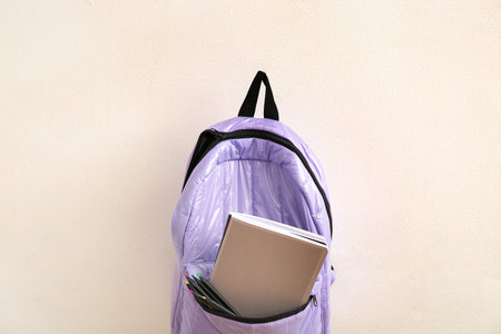 Lilac school backpack with stationery on light backgroundの写真素材