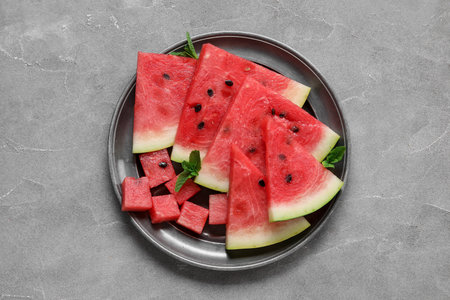 Plate with pieces of ripe watermelon on gray backgroundの写真素材