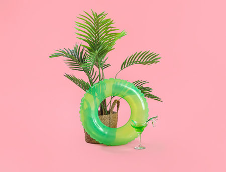 Swim ring with palm and cocktail on pink backgroundの写真素材