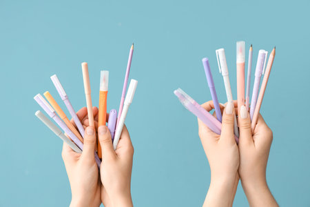 Female hands with school supplies on blue backgroundの写真素材