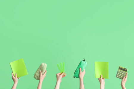 Hands with school accessories on green backgroundの写真素材