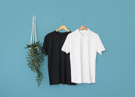 Stylish t-shirts hanging on blue backgroundの写真素材