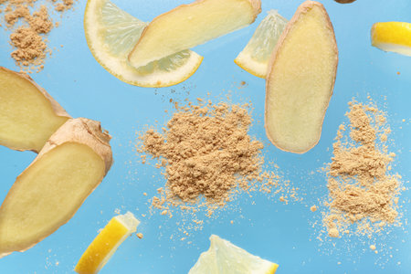 Slices of fresh ginger root with dried powder and lemon on blue backgroundの写真素材
