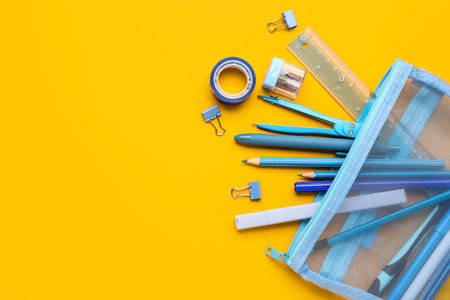 Pencil case with different stationery on orange backgroundの写真素材