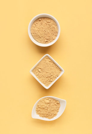 Bowls with ginger powder on yellow backgroundの写真素材