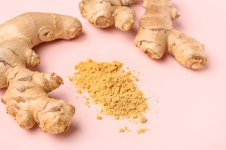 Fresh ginger roots and dried powder on pink backgroundの写真素材
