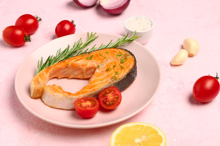 Plate of tasty salmon steak on pink backgroundの写真素材