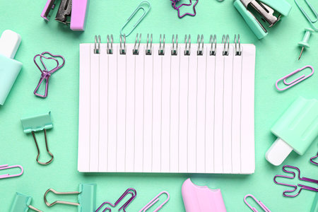 Notebook with different stationery supplies on turquoise backgroundの写真素材