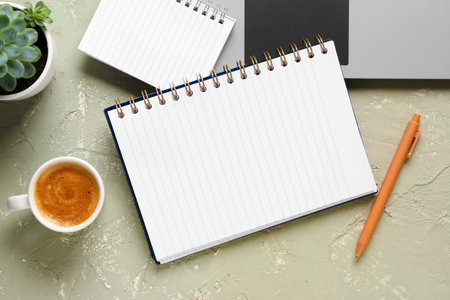 Notebooks and cup of tasty coffee on gray backgroundの写真素材