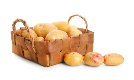 Wicker basket with fresh raw potatoes on white backgroundの写真素材