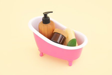 Small bathtub with cosmetic products on color backgroundの写真素材