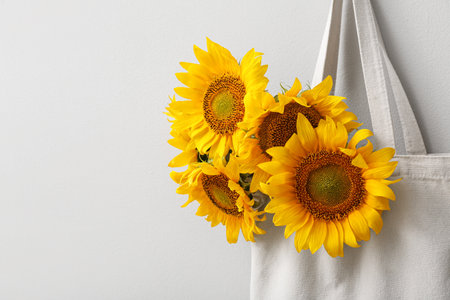 Eco bag with beautiful sunflowers on white backgroundの写真素材