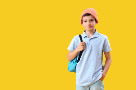 Portrait of schoolboy with backpack on orange backgroundの写真素材