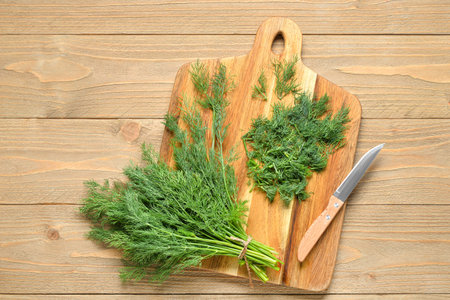 Board with fresh dill on wooden backgroundの写真素材