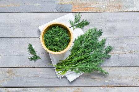 Bowl with fresh dill on gray wooden backgroundの写真素材